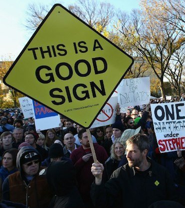 The Good Sign Guy carries the giant yellow This Is A Good Sign through the crowd at the Rally to Restore Sanity in Washington DC