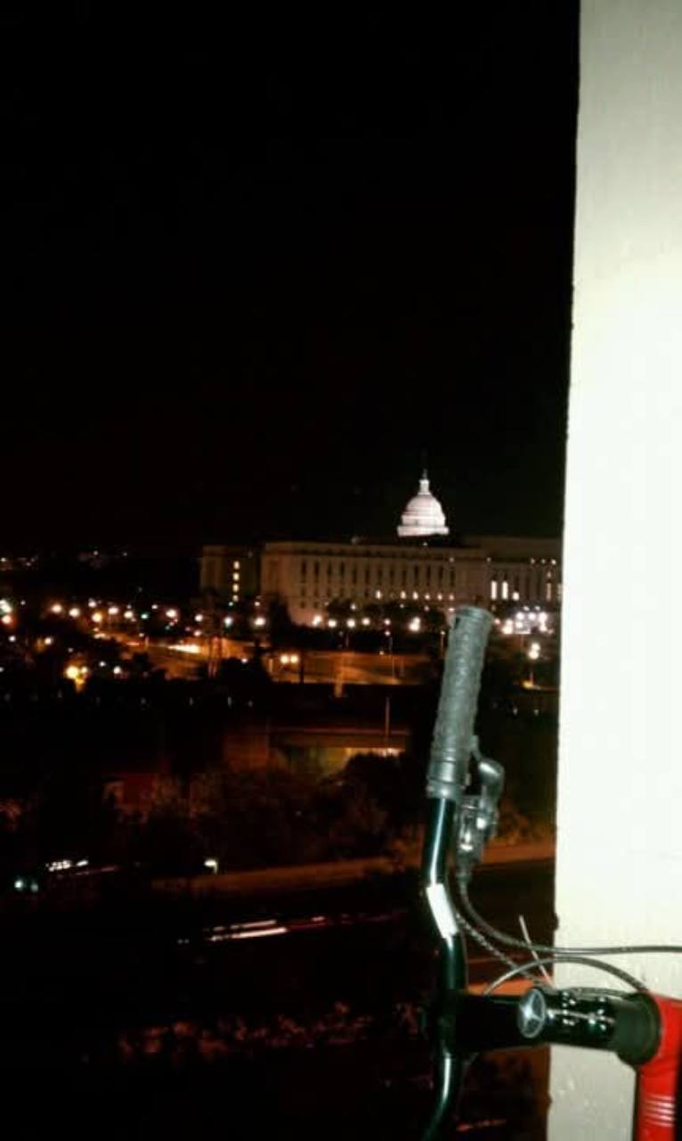 Night view from a balcony toward the illuminated U.S. Capitol before the rally