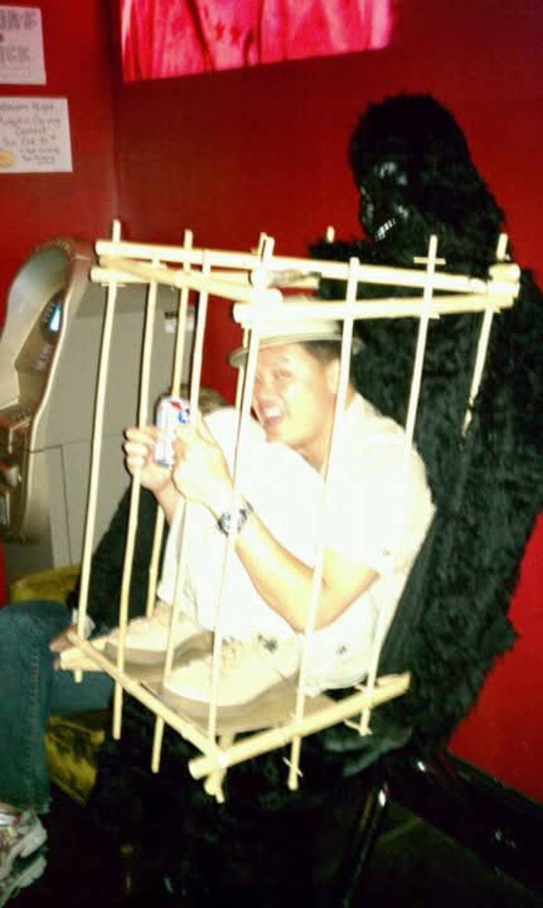 A man in a handmade cage costume with a gorilla-costumed person behind him at a Halloween gathering the night before the rally